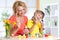 Happy mother and child girl preparing to Easter holiday and with brush coloring eggs