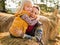 Happy mother and child hugging while on haystack