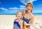 Happy mother and child on seashore applying suntan lotion