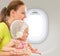 Happy mother and child sitting together in airplane cabin