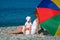 Happy mother with child under umbrella on beach