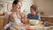 Happy mother with children having fun and playing on kitchen while cooking. Children cooking with parents, little chef