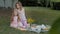 A happy mother combs her daughter`s hair. Family in a city park on a picnic on a warm evening at sunset.