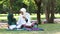 Happy mother and cute daughter sitting in park spent holiday together, Muslim teacher and preschool kids girl pray or read Quran b