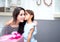 happy of mother and daughter asian with gift with pink ribbon and daughter kissing mother.