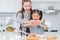 Happy Mother and Daughter is breaking egg to make Bakery in kitchen together, for family fun activity concept