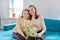 Happy mother and daughter child congratulating with bouquet of flowers and card