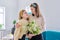 Happy mother and daughter child congratulating with bouquet of flowers and card