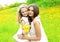Happy mother and daughter child together with yellow dandelion flowers