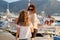 Happy mother and daughter child walking together holding hands along seafront