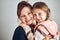 Happy mother and daughter embracing, hugging and smiling together. Family portrait. Happy moment. Woman and little girl posing to