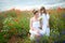 Happy mother and daughter hugging among the flowering meadows of