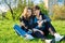 Happy mother and daughter hugging sitting on grass