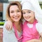 Happy mother and daughter in pink apron.