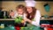 Happy mother and daughter preparing cupcakes in kitchen. Dramatic color grading