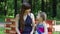 Happy mother and daughter sit on bench in park at summer