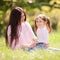 Happy mother and daughter in the summer park. Beauty nature scene with family outdoor lifestyle. Happy family resting together