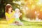 Happy mother and daughter in sunny summer park. Beauty nature scene with family outdoor lifestyle. Happy family resting together