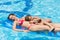 Happy mother and daughter swimming in the pool