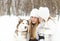 Happy mother with daughter in the winter park with huskies dog