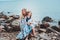 Happy mother and daughter wrapped in quilt blanket spending time together on the beach on summer vacation. Happy family traveling