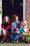 happy mother and daughters sit on porch of their house