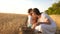 Happy mother farmer plays with little son, daughter in the field. mother and little child are playing with grain in a