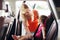 Happy mother fastening child with car seat belt