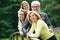 Happy mother and father standing with two daughters outdoors