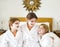 Happy mother and girls in bathrobes with cream mask