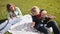 Happy mother, grandmother and little baby resting on green grass.