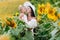 Happy mother in hat with the daughter in the field with sunflowers. mom and baby girl having fun outdoors. family concept. mom