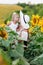 Happy mother in hat with the daughter in the field with sunflowers. mom and baby girl having fun outdoors. family concept. mom