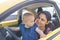 Happy mother and her adorable baby in yellow compact car