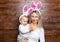 Happy mother and her cute child wearing bunny ears, getting ready for Easter