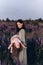 Happy mother and her little daughter in a field of lupins in summer. Mom holds her baby in arms