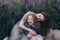 Happy mother and her little daughter in a field of lupins in summer. Mom hugs a happy baby