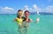 Happy mother and kid snorkeling in tropical sea