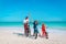 Happy mother with kids biking at beach