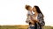 Happy mother kisses her little daughter on a green meadow at sunset. young woman holding her baby. motherhood and