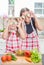 Happy mother and little daughter   playing with zucchini slices on the eyes at home kitchen having fun in healthy nutrition and ed