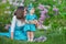 Happy mother mom with daughter enjoying time on a awesome place between lilac syringe bush.Young ladies with basket full of flower