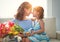 Happy mother`s day! child daughter gives mother a bouquet of f