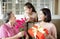 Happy mother`s day  . Child and  mother congratulating grandmother  giving her flowers and  gift box