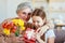 Happy mother`s day! granddaughter gives flowers and congratulates an grandmother on holiday