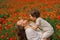 Happy Mother's Day. Little boy and mother is playing in a beautiful field of red poppies