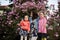 Happy Mother\\\'s Day. Mother with two daughters enjoying nice spring day near magnolia blooming tree