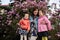 Happy Mother\\\'s Day. Mother with two daughters enjoying nice spring day near magnolia blooming tree