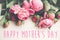 Happy mother`s day text on pink peonies bouquet on rustic white
