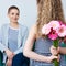 Happy Mother`s Day, Women`s day or Birthday background. Cute little girl giving mom bouquet of pink gerbera daisies. Loving mother